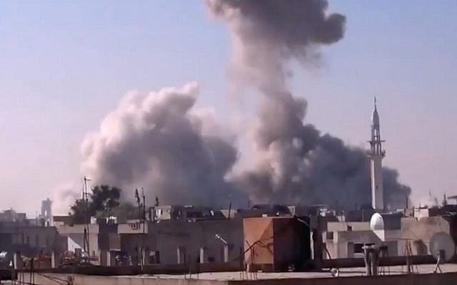 smoke rises from a building in Homs, Syria, after heavy shelling (photo credit: Shaam News Network via AP video) smoke rises from a building in Homs, Syria, after heavy shelling (photo credit: Shaam News Network via AP video)