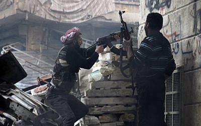 Free Syrian Army fighters fire at enemy positions during heavy clashes with government forces, in the Salaheddine district in Aleppo, Syria, on Saturday, Dec. 29 (photo credit: AP/Abdullah Al-Yasin)