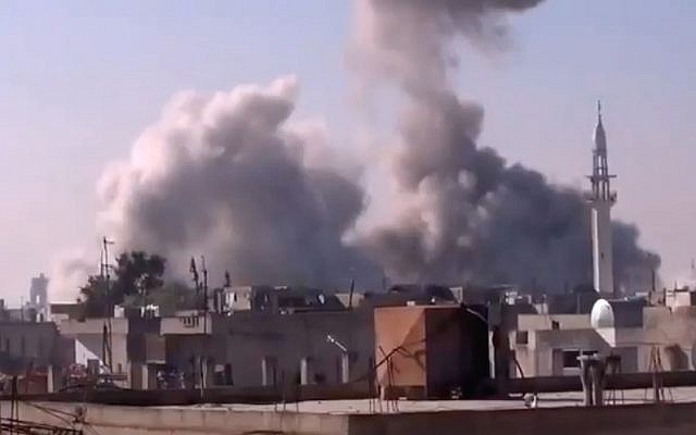 In this image, taken from video obtained from the Shaam News Network, which has been authenticated based on its contents and other AP reporting, smoke rises from buildings from heavy shelling in Homs, Syria on Thursday (photo credit: AP Photo/Shaam News Network via AP video)