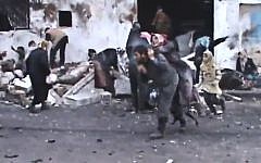 A Syrian man carries an elderly woman after a government airstrike hit the Hama suburb of Halfaya, Syria, on Sunday December 23, 2012. (photo credit: Shaam News Network via AP video)