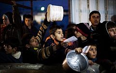 Syrian children wait in line for food at a refugee camp near the Turkish border, in Azaz, Syria, last December (photo credit: AP/Manu Brabo)