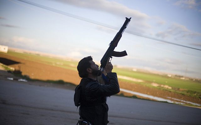 A Free Syrian Army fighter points his weapon as he watches a Syrian Army jet, not pictured, in Fafeen village, north of Aleppo province, Syria, on Tuesday, December 11, 2012. (photo credit: AP Photo/Manu Brabo) A Free Syrian Army fighter points his weapon as he watches a Syrian Army jet, not pictured, in Fafeen village, north of Aleppo province, Syria, on Tuesday, December 11, 2012. (photo credit: AP Photo/Manu Brabo)