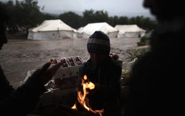 Syrians, who fled their homes with their families, gather around a fire to warm themselves at a makeshift vegetables store in a camp for the displaced in the village of Atmeh, Syria, Tuesday, Dec. 18, 2012. (Photo credit: AP/Muhammed Muheisen) Syrians, who fled their homes with their families, gather around a fire to warm themselves at a makeshift vegetables store in a camp for the displaced in the village of Atmeh, Syria, Tuesday, Dec. 18, 2012. (Photo credit: AP/Muhammed Muheisen)