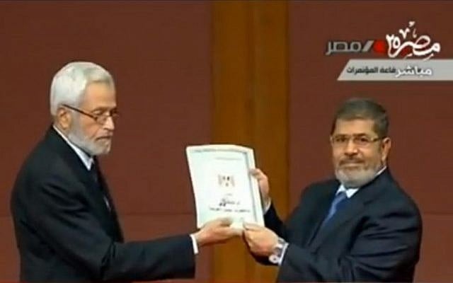 Egyptian President Mohammed Morsi receiving the new draft Egyptian constitution on Saturday. (photo credit: image capture from Egyptian national TV)