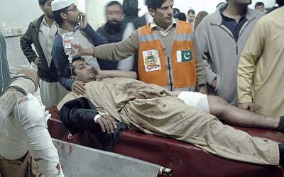 Injured victims of a suicide bombing are treated at a local hospital in Peshawar, Pakistan, Saturday, Dec. 22, 2012. A suicide bomber in Pakistan killed several people, including a provincial government official, at a political rally held Saturday by a party that has opposed the Taliban, officials said. (AP Photo/Mohammad Sajjad)