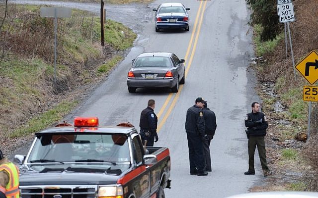 Local law enforcement block off a road near Canoe Creek State Park, Pa. while investigating a shooting on Friday. The suspect fired at troopers responding to other shootings Friday morning. The fleeing gunman then crashed head-on into a trooper's car and got out of his truck and shot again at police, who returned fire and killed him. (photo credit: AP Photo/Altoona Mirror, J.D. Cavrich) Local law enforcement block off a road near Canoe Creek State Park, Pa. while investigating a shooting on Friday. The suspect fired at troopers responding to other shootings Friday morning. The fleeing gunman then crashed head-on into a trooper's car and got out of his truck and shot again at police, who returned fire and killed him. (photo credit: AP Photo/Altoona Mirror, J.D. Cavrich)