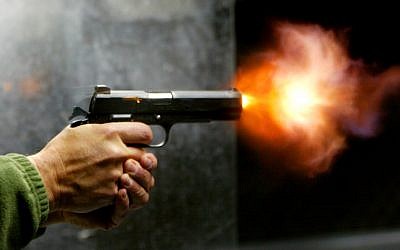 A man fires his handgun (photo credit: Olivier Fitoussi/Flash90)