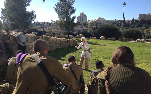 An actor with the Western Wall Heritage Foundation speaking to the soldiers on their way to the Western Wall (photo credit: Mitch Ginsburg/Times of Israel)