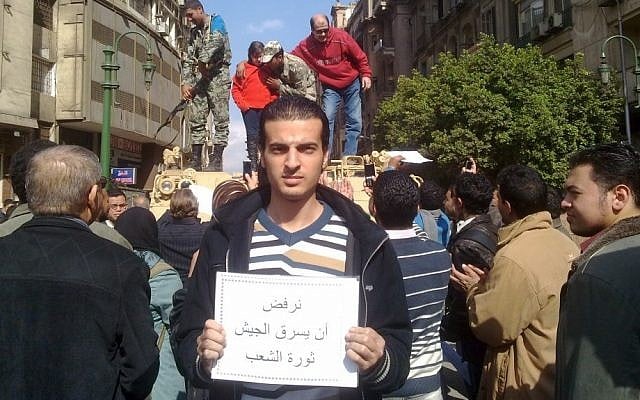 Maikel Nabil in Cairo's Tahrir Square holding a sign saying 'Refusing to let the army steal the people's revolution' (photo credit: Courtesy)