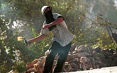 Ilustrative: A Palestinian youth hurls a Molotov cocktail at IDF soldiers near Bethlehem in 2000. (Yossi Zamir/Flash90)
