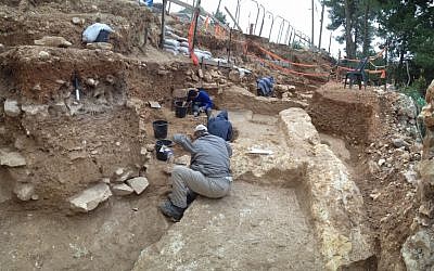 Workers uncover the foundations of ancient buildings under a road in the Jerusalem neighborhood of Kiryat Hayovel (Courtesy of the Israel Antiquities Authority)