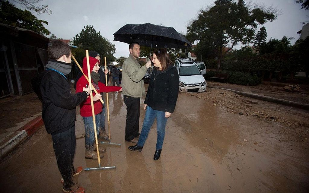 Labor Party leader Shelly Yachimovich speaks with locals in Bat Hefer as her aide holds her umbrella. (photo credit: Shelly Yachimovich/Facebook) Labor Party leader Shelly Yachimovich speaks with locals in Bat Hefer as her aide holds her umbrella. (photo credit: Shelly Yachimovich/Facebook)
