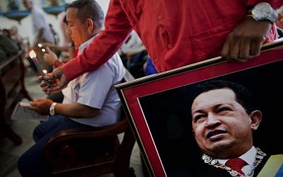A Venezuelan Embassy worker holds a framed image of Venezuela's ailing President Hugo Chavez in Havana, Cuba, earlier this month (photo credit: AP/Ramon Espinosa)