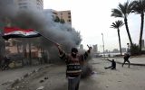 A protester, part of the Black Bloc, holds the Egyptian national flag during clashes with riot police near Tahrir Square, Cairo, Egypt, Monday, Jan. 28, 2013 (photo credit: AP/Khalil Hamra)