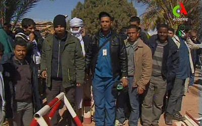 Unidentified rescued hostages pose for the media in Ain Amenas, Algeria, in this image taken from television Friday. (AP Photo/Canal Algerie via Associated Press TV)