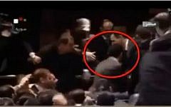 Syrian President Bashar Assad receiving an inadvertant head butt from his body guard (YouTube screen capture)