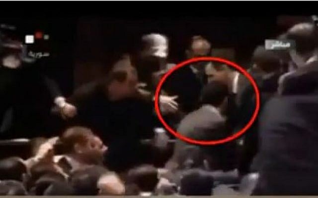 Syrian President Bashar Assad receiving an inadvertant head butt from his body guard (YouTube screen capture)