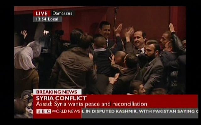 Syrian President Bashar Assad waves at supporters in Damascus's Opera Hall on Sunday, Jan. 6 (image capture: BBC)