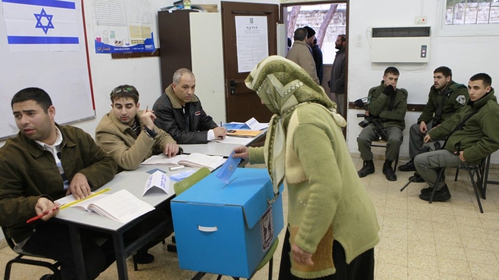 An Arab Israeli woman casts her vote as Israeli border policemen look on at a polling station in the Arab village of Abu Gosh, west of Jerusalem, on February 10, 2009 (photo credit: Nati Shohat/Flash90)
