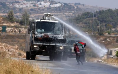 Palestinian demonstrators run from a foul smelling water fired by Israeli security forces during clashes at a protest in the West Bank, July, 2012. (photo credit:Issam Rimawi)