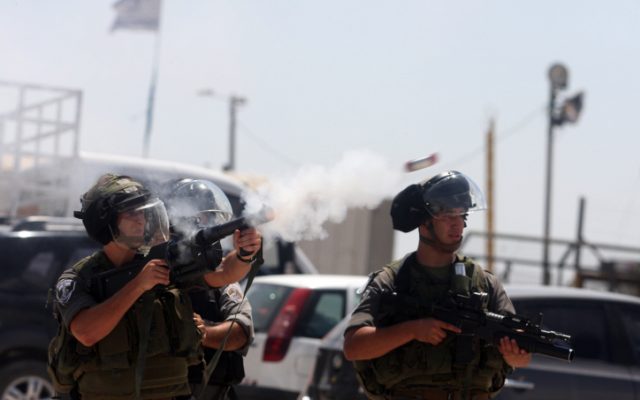 Israeli security personnel fire tear gas at Palestinian protesters, August, 2012. (photo credit: Issam Rimawi/Flash90) Israeli security personnel fire tear gas at Palestinian protesters, August, 2012. (photo credit: Issam Rimawi/Flash90)