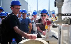Visitors top up their glasses with treated seawater at a desalination plant near Hadera, Israel. (Shay Levy/Flash90)