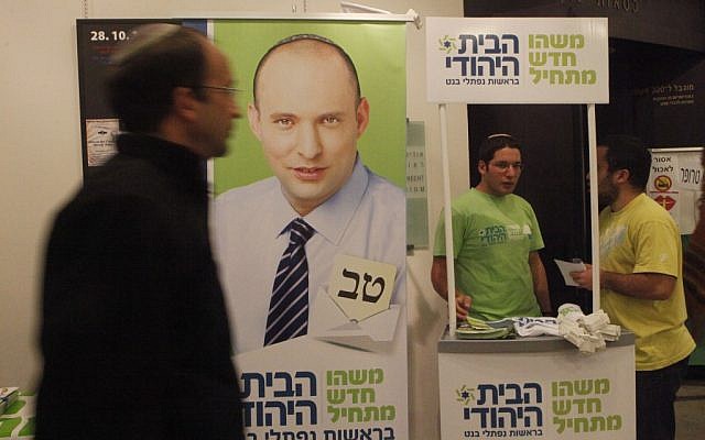 A man walking by a booth for Jewish Home in Jerusalem in December. (photo credit: Miriam Alster/Flash90)