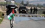 A Palestinian throwing stones at Israeli troops in the West Bank in December. (photo credit: Issam Rimawi/Flash90)