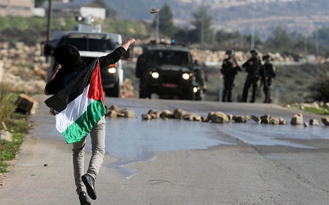 A Palestinian throwing stones at Israeli troops in the West Bank in December. (photo credit: Issam Rimawi/Flash90) A Palestinian throwing stones at Israeli troops in the West Bank in December. (photo credit: Issam Rimawi/Flash90)