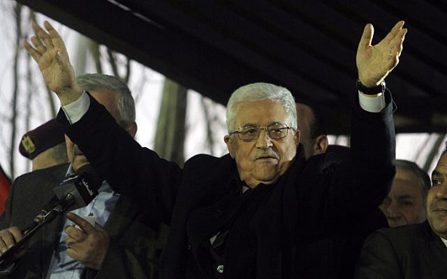 Palestinian Authority President Mahmoud Abbas waves to Fatah supporters during a rally marking the 48th anniversary of the movement's founding in Ramallah, December 31 (photo credit: Issam RImawi/Flash90)