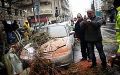 A car damaged by a fallen tree in Jerusalem, Monday (photo credit: Miriam Alster/Flash90)