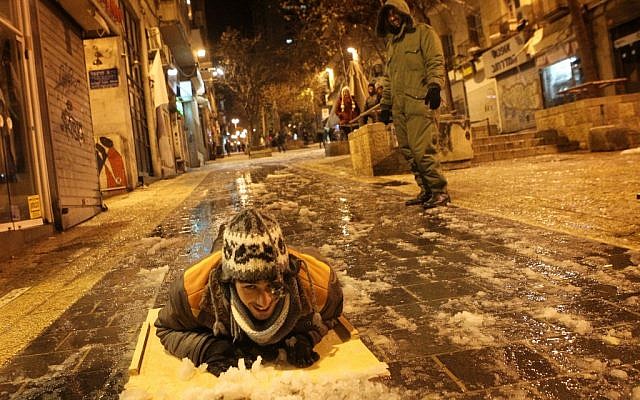 A man sleds down the normally crowded Ben Yehuda pedestrian mall. (photo credit: Miriam Alster/Flash90) A man sleds down the normally crowded Ben Yehuda pedestrian mall. (photo credit: Miriam Alster/Flash90)
