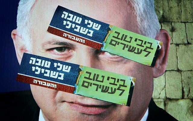 Labor Party campaign stickers saying "Bibi is good for the rich, Shelly is good for me" posted on top of a campaign poster depicting Prime Minister Benjamin Netanyahu (Miriam Alster/Flash90)
