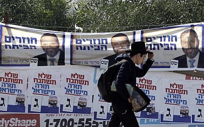 An ultra-Orthodox Jewish young man passes posters of the ultra-Orthodox Shas party Friday, Jan. 18, 2013.(photo credit: Tsafrir Abayov/Flash90)