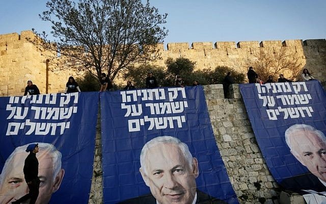 Outside the walls of Jerusalem's Old City, supporters of Prime Minister Benjamin Netanyahu unfold huge signs that read, "Only Netanyahu will protect Jerusalem," on Sunday (photo credit: Miriam Alster/Flash90)