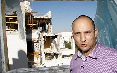 Jewish Home leader Naftali Bennett a building in Rishon Lezion which was struck by a missile fired from the Gaza Strip in November, a day before the parliamentary elections on January 21, 2013. (photo credit: Roy Alima/Flash90)