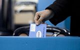 Illustrative: A woman places her vote in a ballot box for the Israeli general elections for the 19th parliament, January 22, 2013, in Jerusalem. (Yonatan Sindel/Flash90)
