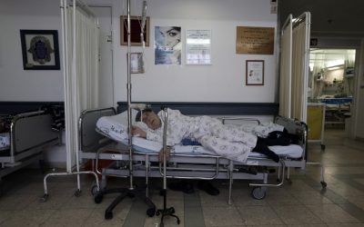Overcrowding at hospitals has forced many patients to lie on beds in the corridors, like this man at Barzilai Hospital in Ashkelon on Monday. (photo credit: Tsafrir Abayov/Flash90)