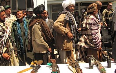 Illustrative photo of former Taliban fighters relinquishing their rifles to Afghan government officials in Ghor, Afghanistan, May 2013 (photo credit: Joe Painter/US Department of Defense)