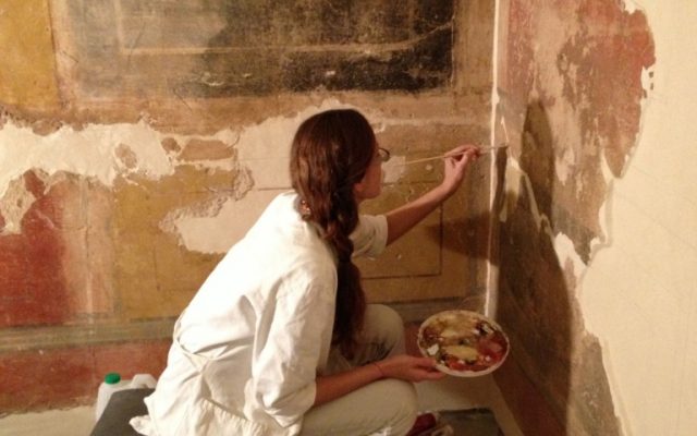 The quality and shades of the paints used in Herod's palaces attest to his stature in the international arena; here, putting some finishing touches on several wall panels (photo credit: Jessica Steinberg/Times of Israel)