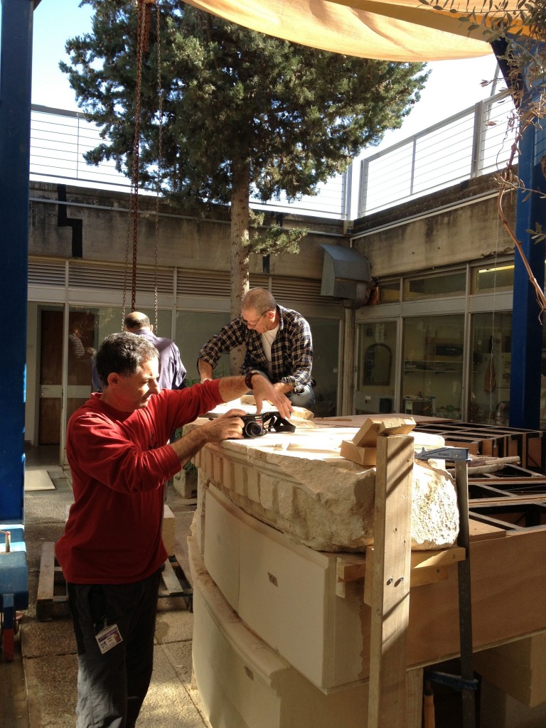 Paolo Recanati and fellow staff getting ready to lift reconstructed pillars from the VIP room and mausoleum to the exhibition room with the help of a crane (photo credit: Jessica Steinberg/Times of Israel)
