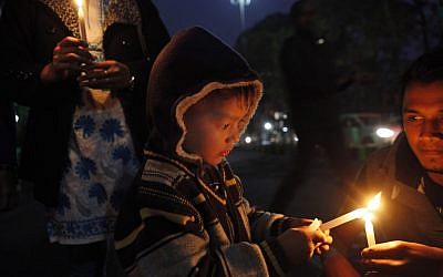 A young boy participates in a candlelight vigil protesting against a leader of the ruling Congress party on accusations he raped a woman in a village in the early hours of the morning, in Gauhati, India, Friday. Footage on Indian television showed the extraordinary scene of local women surrounding Bikram Singh Brahma, ripping off his shirt and repeatedly slapping him across the face. A Dec. 16 gang rape on a woman, who later died of her injuries, has caused outrage across India, sparking protests and demands for tough new rape laws, better police protection for women and a sustained campaign to change society's views about women. (AP Photo/Anupam Nath)