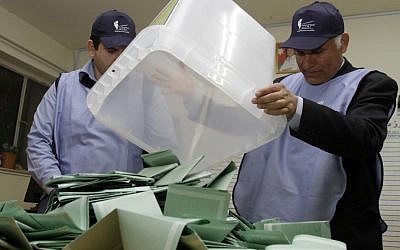 Jordanian officials empty a ballot box in Amman, Wednesday (photo credit: Raad Adayleh/AP)