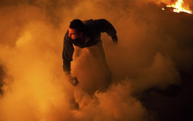 A protester prepares to throw a rock while surrounded by tear gas and smoke during clashes with security forces near Tahrir Square in Cairo, Egypt, on January 27, 2013. (photo credit: AP/Virginie Nguyen Hoang)