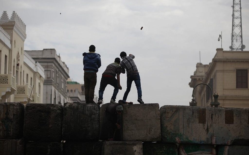 Skirmishes break out between protesters and security forces, unseen, near Tahrir Square, Cairo, Egypt, Friday. (AP Photo/Khalil Hamra)