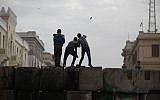 Skirmishes break out between protesters and security forces, unseen, near Tahrir Square, Cairo, Egypt, Friday. (AP Photo/Khalil Hamra)