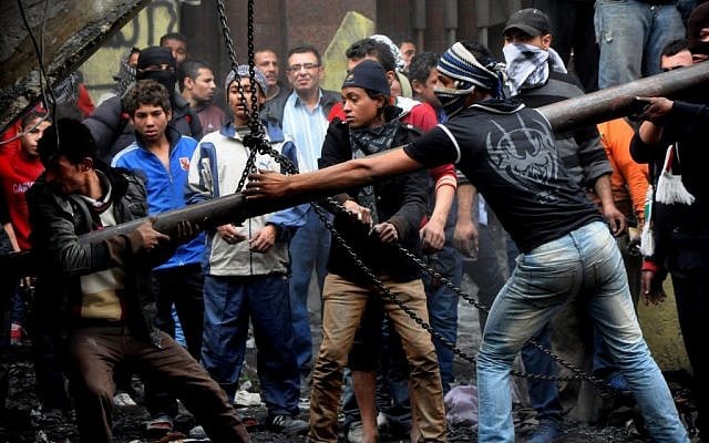 Egyptian protesters try to tear down a cement wall built to prevent them from reaching parliament and the Cabinet building near Tahrir Square, in Cairo, Egypt, Thursday, Jan. 24, 2012. (photo credit: AP/Hussein Tallal) Egyptian protesters try to tear down a cement wall built to prevent them from reaching parliament and the Cabinet building near Tahrir Square, in Cairo, Egypt, Thursday, Jan. 24, 2012. (photo credit: AP/Hussein Tallal)