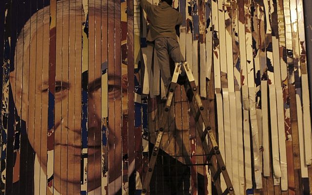 A worker removes an election banner of Prime Minister Benjamin Netanyahu, in Tel Aviv, on Wednesday, Jan. 23 (photo credit: AP/Ariel Schalit) A worker removes an election banner of Prime Minister Benjamin Netanyahu, in Tel Aviv, on Wednesday, Jan. 23 (photo credit: AP/Ariel Schalit)