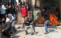 Palestinians throwing rocks at Israeli troops in the West Bank town of Tamoun, January 1. (photo credit: AP/Mohammed Ballas)