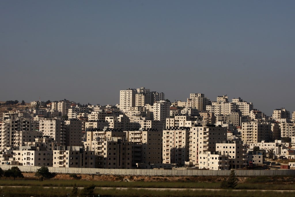 The unregulated buildings of the Kufr Aqab neighborhood of Jerusalem, with the security barrier in the foreground (photo credit: AP Photo/Majdi Mohammed)